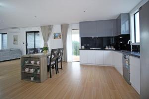 a kitchen and dining room with a table and chairs at Your Private Escape with city views in Auckland