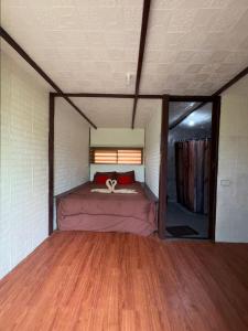 a bed in a small room with a wooden floor at Sobral Rice Terraces View in Antihon
