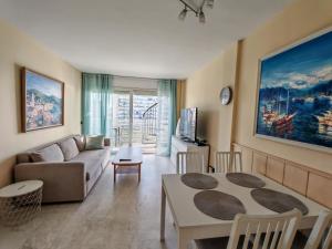 a living room with a couch and a table at Seafront apartment S'Abanell Central Park with pool in Blanes