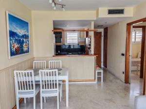 a kitchen and dining room with a table and chairs at Seafront apartment S'Abanell Central Park with pool in Blanes