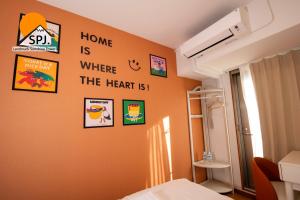 a bedroom with an orange wall with pictures on it at Landmark Sunshine Hotel in Osaka