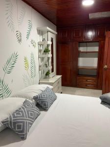 a bedroom with a white bed with two pillows at Hostal Amelia Filandia in Filandia