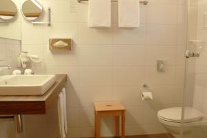 a white bathroom with a sink and a toilet at BnB Chalet-Gafri - Frühstückspension in Wilderswil