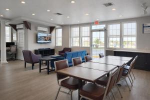 a conference room with tables and chairs and a tv at Motel 6 Lake City, FL – Medical Center in Lake City