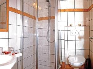a bathroom with a shower and a toilet and a sink at Hotel-Pension Flora in Saalbach Hinterglemm +36 photos