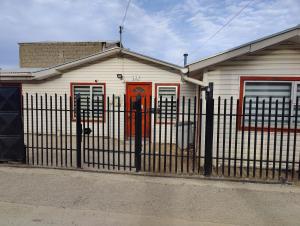 a house with an iron fence in front of it at Casa amoblada en Punta arenas in Punta Arenas
