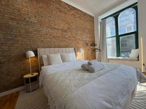a bedroom with a large bed with a brick wall at Top Location - The 777 Old Port Gem in Montreal