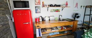a red refrigerator next to a table with a microwave at The Poolhouse in Matamata