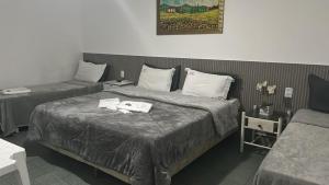 a hotel room with two beds with towels on the bed at Pousada El Shaddai- Prox a BR 101 e Shopping Patarge in Campos dos Goytacazes