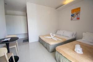 a small room with two beds and a table at ILA Apartelle Boracay in Boracay +93 photos