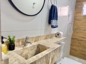 a bathroom with a stone sink and a mirror at Apto moderno no Centro Com Ar e Wi-Fi in Caruaru +23 photos