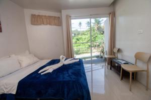 a woman laying on a bed in a bedroom with a window at ILA Apartelle Boracay in Boracay