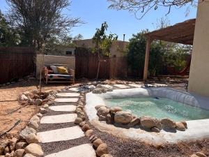 a small swimming pool with rocks in a yard at מים במדבר in Zuqim