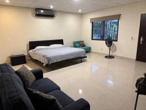 a bedroom with a bed and a couch in a room at Fourth Studio and Festivities in Guararé