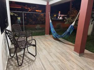 a patio with a hammock and a chair on a porch at Fourth Studio and Festivities in Guararé