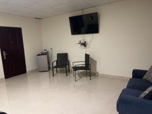 a living room with two chairs and a flat screen tv at Fourth Studio and Festivities in Guararé +3 photos