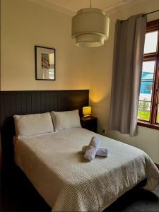 a bedroom with a bed with a towel on it at Waitaki Hotel Kurow in Kurow