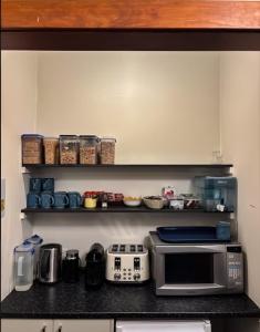 a kitchen with a counter top with a microwave at Waitaki Hotel Kurow in Kurow