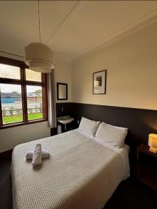 a bedroom with a large bed with a robe on it at Waitaki Hotel Kurow in Kurow