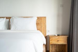 a bedroom with a bed and a wooden night stand at 2BR Rice Field View Private Villa in Cemagi in Canggu