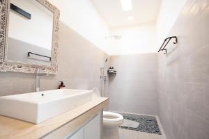a white bathroom with a sink and a toilet at 2BR Rice Field View Private Villa in Cemagi in Canggu +8 photos