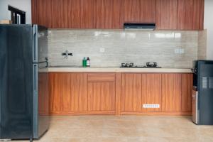 a kitchen with wooden cabinets and a refrigerator at 2BR Rice Field View Private Villa in Cemagi in Canggu