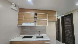 a kitchen with wooden cabinets and a sink at LTG Grand Hotel Cebu in Cebu City +58 photos
