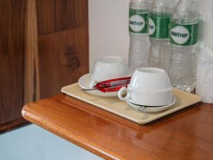 a table with two cups and bottles of water at Riverside Houayxay Hotel in Ban Houayxay