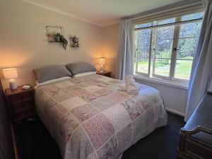 a bedroom with a bed with a teddy bear on it at Mirradong Cottage in Berambing