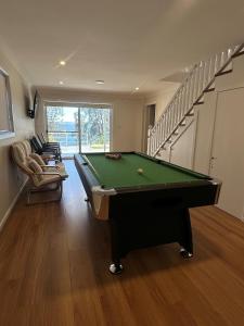 a living room with a pool table and stairs at Angels Little Haven in Cams Wharf