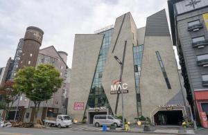 a large building with cars parked in front of it at Daejeon Yuseong MAC Hotel in Yusŏng