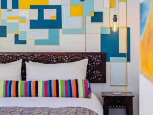a bedroom with a bed and a colorful wall at The Warren @White.Rabbit.House in Plettenberg Bay