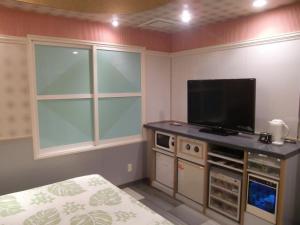 a bedroom with a flat screen tv and a bed at GOLF Kofu Showa(Adult Only) in Kofu +22 photos