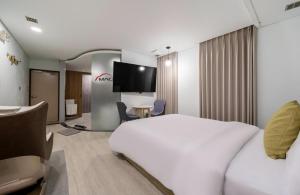 a hotel room with a white bed and a tv at Daejeon Yuseong MAC Hotel in Yusŏng +24 photos