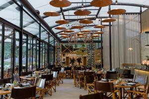 a dining room with tables and chairs and chandeliers at Rodavento Valle de Bravo in Valle de Bravo