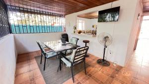 a dining room with a table and chairs and a fan at Casa Pochote, Cobano in Cóbano