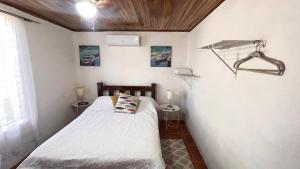 a small bedroom with a bed and two night stands at Casa Pochote, Cobano in Cóbano +12 photos
