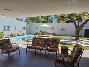 a patio with chairs and a table and a pool at Casa Ninhal, super central, nova e espaçosa. in Bonito