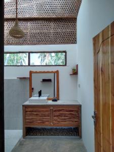 a bathroom with a sink and a mirror at LalaMafia Bungalow in Utende