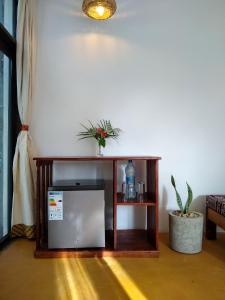 a television in a room with a table with a plant at LalaMafia Bungalow in Utende +41 photos