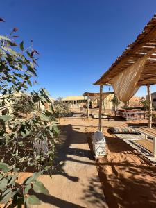 a walkway with a roof and a table and a building at Best Classic Sahara Experiences in Merzouga