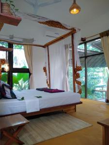 a bedroom with a bed in a room with windows at LalaMafia Bungalow in Utende