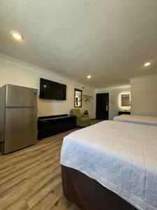 a hotel room with a bed and a flat screen tv at Home Suites in Thief River Falls