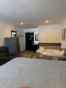 a hotel room with a bed and a bath tub at Home Suites in Thief River Falls