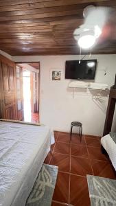 a bedroom with a bed and a flat screen tv at Casa Pochote, Cobano in Cóbano