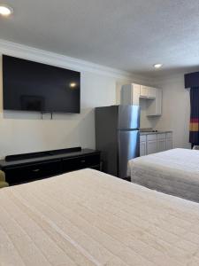 a hotel room with two beds and a flat screen tv at Home Suites in Thief River Falls +18 photos