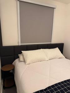 a bedroom with a bed with a large window at Vertice House - Copacabana in Uberlândia
