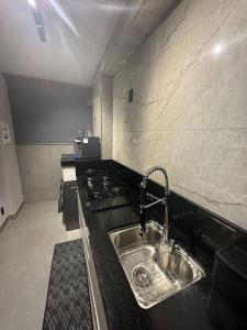 a kitchen with a sink and a stove at Vertice House - Copacabana in Uberlândia +37 photos