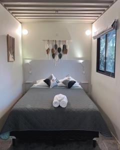 a bedroom with a bed with two towels on it at Green Sanctuary Hotel in Nosara