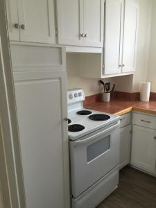 a kitchen with a white stove and white cabinets at Downtown Apt #6 Amazing View - 23 Queen's Rd in St. John's